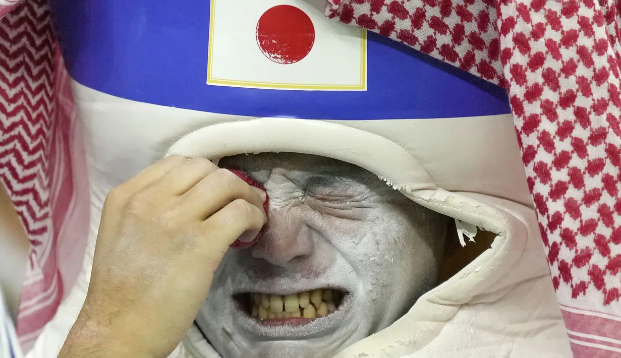Suporter Jepang menangis usai ditaklukkan Kroasia pada babak 16 besar Piala Dunia 2022. Tim Samurai Biru kalah adu penalti dengan skor 1-3 dari Kroasia. (AP/Francisco Seco)