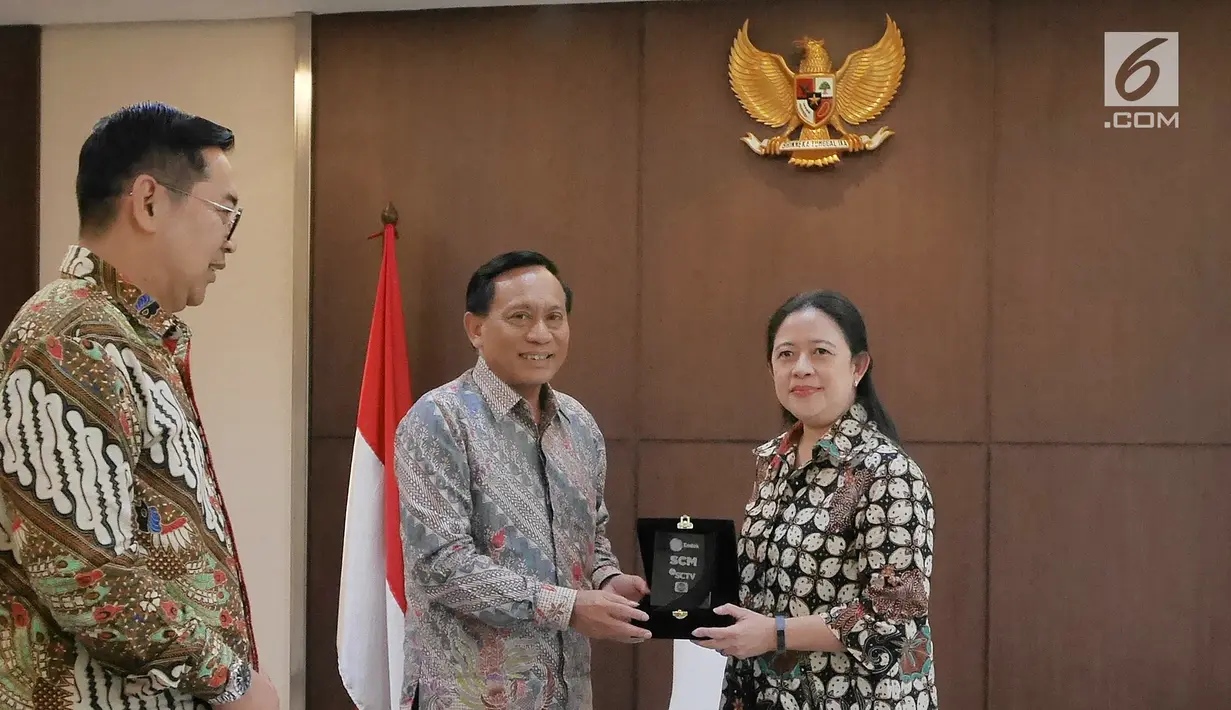 Direktur Utama Indosiar Imam Sudjarwo (tengah) memberikan cenderamata kepada Menko PMK Puan Maharani saat kunjungan ke kantor Kemenko PMK, Jakarta, Selasa (19/2). (Liputan6.com/Herman Zakharia)
