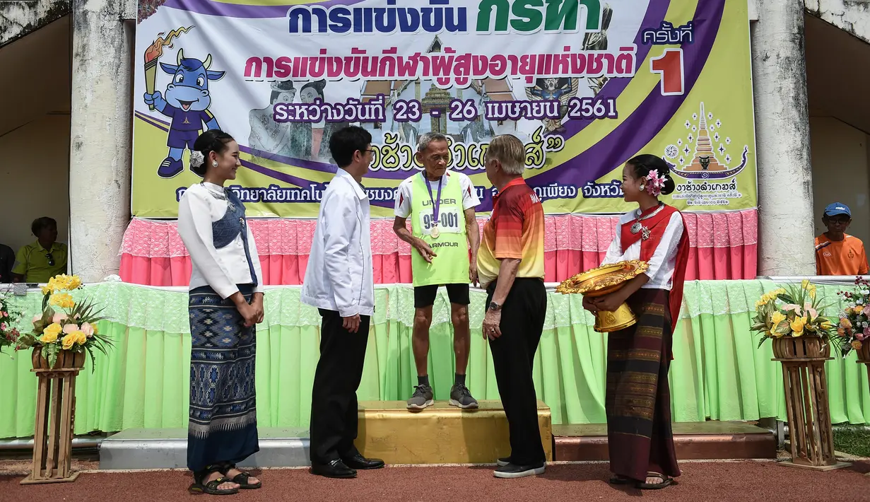 Seorang pria berusia 98 tahun, Sawang Janpram menerima medali usai memenangkan pertandingan Elderly Games nasional di Thailand (25/4). (AFP/Lillian Suwanrumpha)