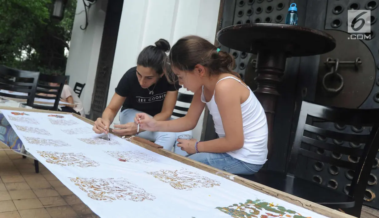 Dua wanita Amerika Latin saat membuat batik dalam kelas bersama Rumah Batik Palbat di Tugu Kunstring Paleis, Jakarta, Kamis (22/3). Kegiatan membuat batik tulis dan batik cap ini hasilnya akan didonasikan untuk amal. (Merdeka.com/Arie Basuki)
