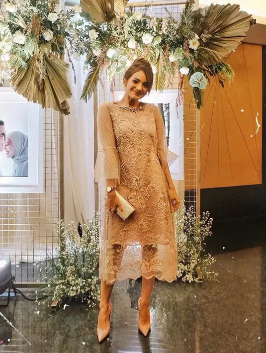 Kamu juga bisa sontek midi dress beraksen bunga dan manik di bagian kerah Enzy Storia yang tampak anggun ini. (Instagram/enzystoria).