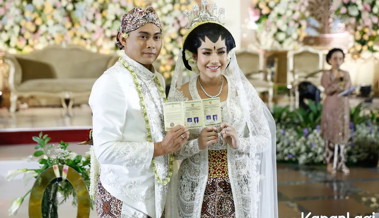 Senyum bahagia Shinta Bachir dan Indra menunjukkan buku nikahnya. Saat menggelar jumpa pers, pasangan ini mengaku tak ada rencana bulan madu.  Hal itu karena Shinta dan Indra sama-sama telah memiliki anak dan masih sekolah. [Foto; KapanLagi.com/Bayu Herdianto]