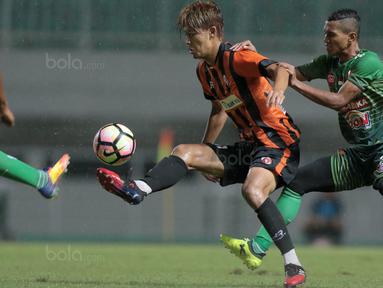 Pemain PS TNI, Abuh Lestaluhu (kanan) menahan laju membayangi gerakan pemain Perseru Serui, Karube Ryutaro pada lanjutan Liga 1 2017 di Stadion Pakansari, Bogor (07/10/2017). PS TNI menang 2-1. (Bola.com/Nicklas Hanoatubun)