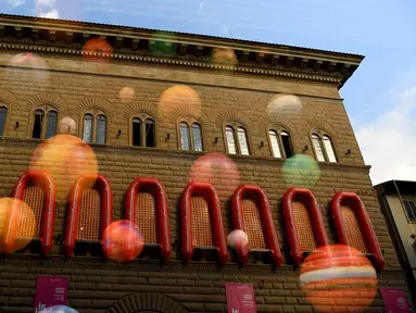 Sebanyak 22 perahu karet berwarna oranye digantungkan di dekat jendela istana dari Strozzi Palace, Italia, Rabu (21/9). Karya seni instalasi seniman fenomenal asal Tiongkok Ai Weiwei itu berjudul “Reframe”. (GABRIEL BOUYS/AFP)