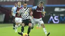 Bek Manchester United, Alex Telles mengumpan bola dari kawalan gelandang West Ham, Tomas Soucek pada pertandingan lanjutan Liga Inggris di stadion London di London, Inggris, Minggu (6/12/2020). MU menang 3-1 atas West Ham. (Adam Davy / Pool via AP)