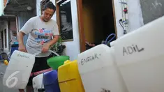 Warga membeli air bersih di Kampung Pasar Ikan Luar Batang, Penjaringan, Jakarta, Senin (28/3). Warga setempat mengaku hampir dua minggu harus membeli air bersih untuk pemenuhan kebutuhan sehari-hari. (Liputan6.com/Gempur M Surya)