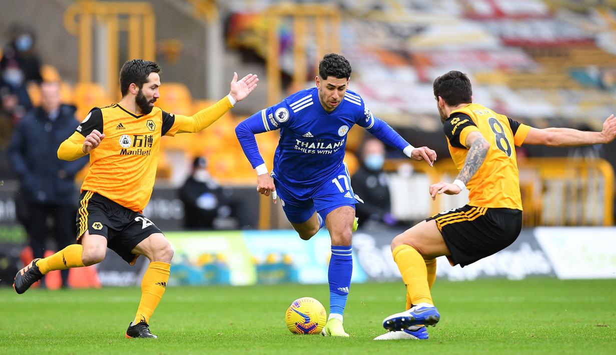 Striker Leicester City, Ayoze Perez (tengah) dikepung dua gelandang Leicester City, Joao Moutinho (kiri) dan Ruben Neves dalam laga lanjutan Liga Inggris 2020/21 pekan ke-23 di Molineux Stadium, Minggu (7/2/2021). Leicester bermain imbang 0-0 dengan Wolverhampton. (AFP/Justin Tallis/Pool)