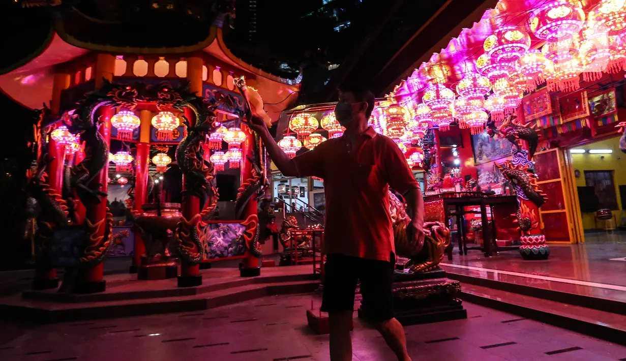 Seorang warga Tionghoa membakar kertas pada malam perayaan Tahun Baru Imlek 2573 di Vihara Amurva Bhumi, Jakarta, Senin (31/1/2022). Ibadah Imlek pada tahun ini dilakukan pembatasan sampai pukul 20.00 akibat pemberlakuan PPKM level tiga di Jakarta. (Liputan6.com/Johan Tallo)