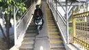 Pengendara sepeda motor melintasi Jembatan Penyeberangan Orang (JPO) di kawasan Pasar Minggu, Jakarta, Jumat (17/7/2020). Rendahnya kesadaran dalam disiplin berkendara menyebabkan sejumlah pengendara sepeda motor melintasi JPO tersebut meski merugikan pengguna lain. (Liputan6.com/Immanuel Antonius)