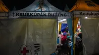 Kerabat menyaksikan para korban gempa bumi mendapatkan perawatan di tenda medis darurat di depan Rumah Sakit Ruteng di Ruteng, Manggarai, Nusa Tenggara Timur, Sabtu malam, 15 Agustus 2025. (AFP/ Juni Kriswanto)
