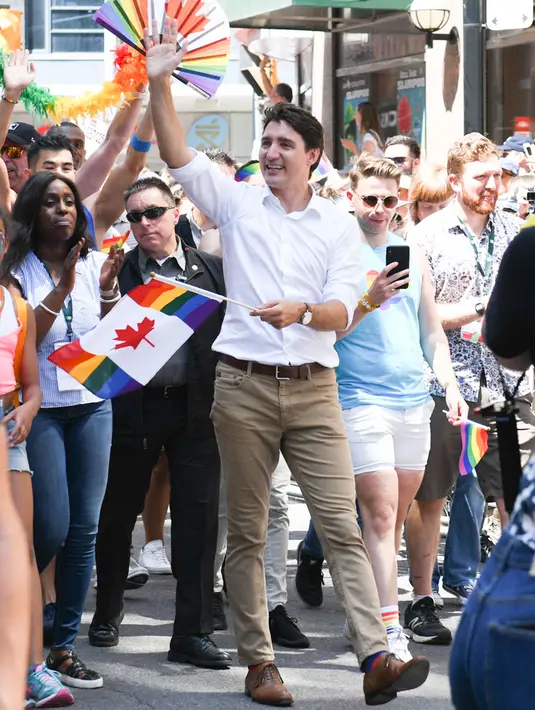 Perdana Menteri Kanada Justin Trudeau berjalan bersama peserta saat mengikuti pawai LGBT Toronto's Pride Parade di Toronto, Kanada, Minggu (23/6/2019). Pawai digelar untuk mengenang peristiwa Stonewall yang terjadi di New York pada Juni 1969. (George Pimentel/GETTY IMAGES NORTH AMERICA/AFP)