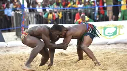 Kouame Roumaric dari Burkinabe (kanan) bertarung dengan Mouhamet Bousso dari Senegal dalam kategori 120 kg Final Gulat Wanita Tradisional selama Francophonie ke-8 di Treichville Sports Park di Abidjan pada 29 Juli 2017. (AFP Photo/Sia Kambou)