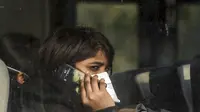 Seorang wanita India berada di dalam bus saat keluar dari Bandara Internasional Indira Gandhi setelah dievakuasi dari kota Wuhan di China, di New Delhi (1/2/2020). Jumlah total kematian akibat wabah virus corona di China tercatat mencapai 259 hingga Jumat (31/1/2020). (AFP/Money Sharma)