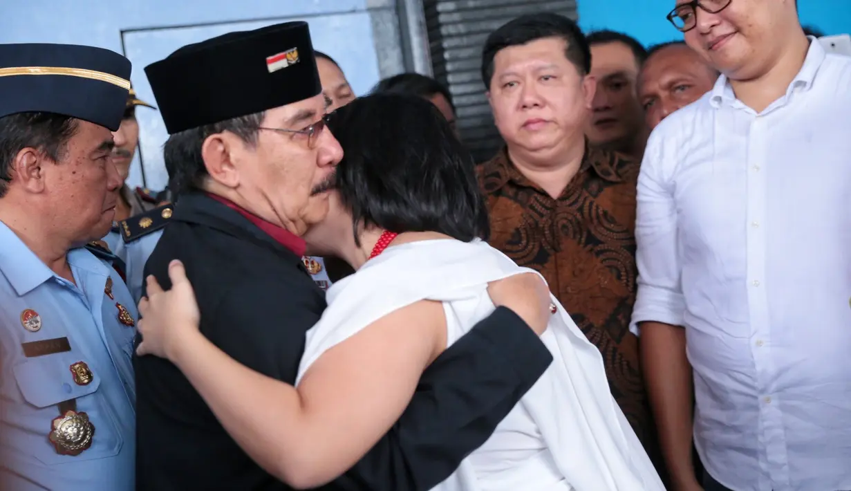Keluar dari pintu, Antasari Azhar mengenakan baju merah tertutup jaket warna hitam. Ia juga mengenakan peci warna hitam dengan pin bendera merah putih dan lambang garuda. (Adrian Putra/Bintang.com)