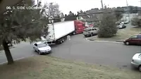 Pengemudi sebuah truk trailer yang sedang berbelok di persimpangan tidak menyadari bahwa truknya telah menyeret mobil parkir.
