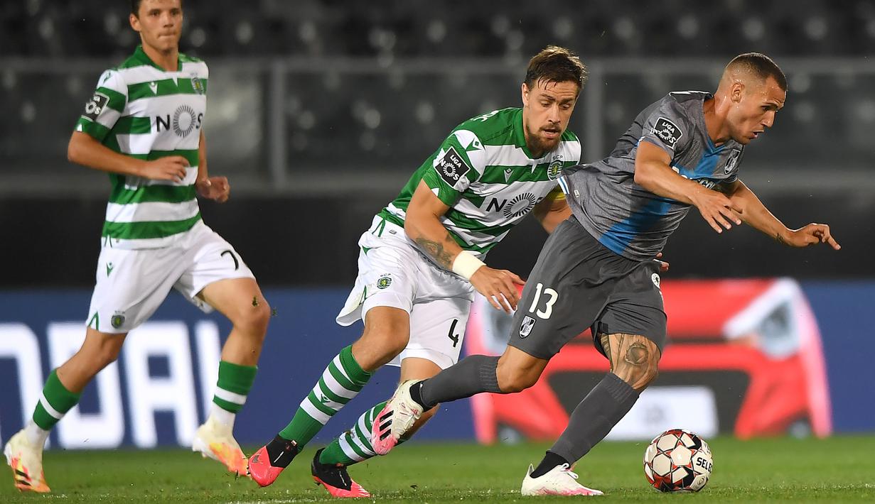 Striker Vitoria Guimaraes, Leo Bonatini, berebut bola dengan pemain Sporting CP pada laga Liga Portugal di Stadion Dom Afonso Henriques, Guimaraes, Kamis (4/6/2020) waktu setempat. Kompetisi Liga Portugal resmi dilanjutkan dengan aturan tanpa penonton di setiap pertandingan. (AFP/Hugo Delgado/pool)