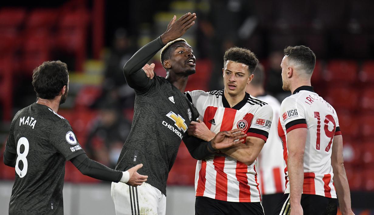 Gelandang Manchester United, Paul Pogba (kedua dari kiri), terlibat pertikaian dengan bek Sheffield United, Jack Robinson (kanan), dalam laga lanjutan Liga Inggris 2020/21 pekan ke-13 di Bramall Lane, Sheffield, Kamis (17/12/2020). Manchester United menang 3-2 . (AFP/Peter Powell).