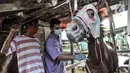 Dokter hewan dari Suku Dinas KPKP Jakarta Timur menyuntikkan vitamin pada kuda delman di kawasan Pengarengan, Cakung, Jakarta, Kamis (25/2/2021). Langkah ini sebagai upaya pengendalian penyakit menular dan peningkatan kesejahteraan kuda delman di masa pandemi COVID-19. (merdeka.com/Iqbal S. Nugroho)