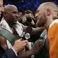 Floyd Mayweather Jr berbicara dengan Conor McGregor setelah bertarung selama 10 ronde di T-Mobile Arena, Las Vegas, Sabtu (26/8/2017) atau Minggu (27/8/2017) WIB. (AP Photo/Isaac Brekken)