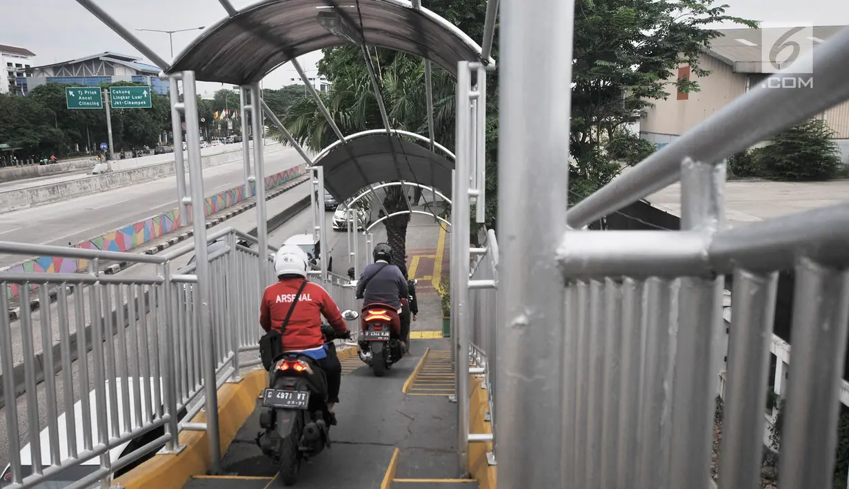 Pengendara sepeda motor melintasi JPO di Jalan Yos Sudarso, Jakarta, Senin (12/11). Aksi nekat yang dilakukan para pengendara sepeda motor demi mempersingkat rute jalan tersebut sangat mengganggu kenyamanan pejalan kaki. (Merdeka.com/Iqbal S. Nugroho)
