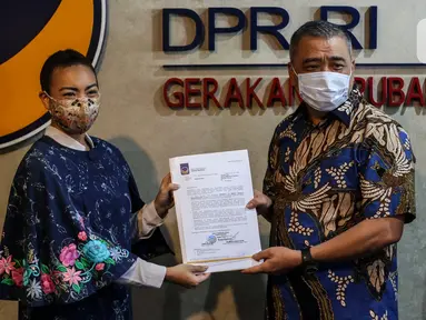 Wakil Ketua Umum DPP Partai NasDem Ahmad Ali (kanan) menyerahkan surat rekomendasi Pilkada kepada Calon Wakil Walikota Tangsel dari Partai Gerindra Rahayu Saraswati Djojohadikusumo (kiri)  di Kompleks Parlemen Senayan, Jakarta. Rabu (29/7/2020). (Liputan6.com/Johan Tallo)