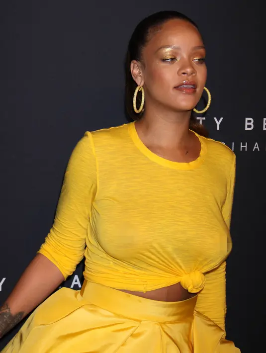 Penyanyi seksi Rihanna menghadiri peluncuran Fenty Beauty by Rihanna di Duggal Greenhouse, New York, Kamis (7/9). Rihanna memodifikasi atasan dengan sedikit mengikat ujung kausnya membentuk simpul tepat di bagian tengah perutnya. (AP Images Photo)