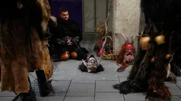 Seorang tampak beristirahat selama mengikuti parade di Munich, Jerman, Minggu (13/12). Krampuss diceritakan sebagai teman Saint Nicholas untuk datang ke rumah - rumah.  (REUTERS/Michael Dalder)