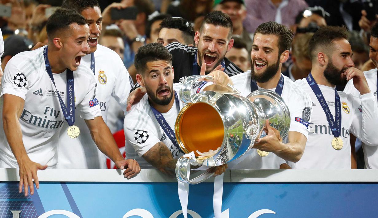 Pemain Real Madrid, Isco sengaja membuang kertas dalam trofi piala Liga Champions usai menang melawan Atletico Madrid pada Final Liga Champions di San Siro Stadium, Milan, (29/5/2016) WIB. (Reuters/Kai Pfaffenbach)