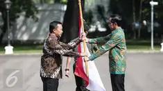 Presiden Jokowi menyerahkan bendera merah putih kepada Menpora Imam Nahrawi sebagai tanda pelepasan keberangkatan Tim Indonesia menuju Olimpiade 2016 di Brasil, di halaman Istana Merdeka, Jakarta, Rabu (22/6). (Liputan6.com/Faizal Fanani)