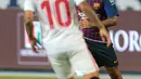 Gelandang Barcelona, Philippe Coutinho menggiring bola dari kawalan gelandang Sevilla pada pertandingan  Piala Super Spanyol di Tangier, Maroko, (13/8). Barcelona berhasil mengalahkan Sevilla dengan skor 2-1. (AP Photo/Mosa'ab Elshamy)
