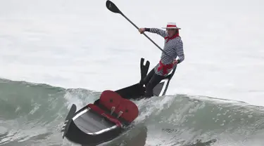  Seorang peserta berpakaian seperti pengayuh gondola mengikuti kontes surfing Haunted Heats Halloween di Santa Monica, California, (29/10). Acara ini untuk merayakan hari Halloween yang jatuh pada tanggal 31 Oktober. (REUTERS/Lucy Nicholson)