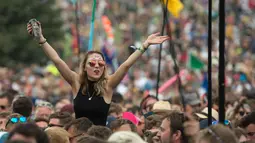 Penonton wanita saat menyaksikan aksi panggung Royal Blood di Festival Musik Glastonbury di Worthy Farm, di Somerset, Inggris, (22/6). Festival Glastonbury merupakan festival musik paling populer di dunia. (AFP Photo/Oli Scarff)