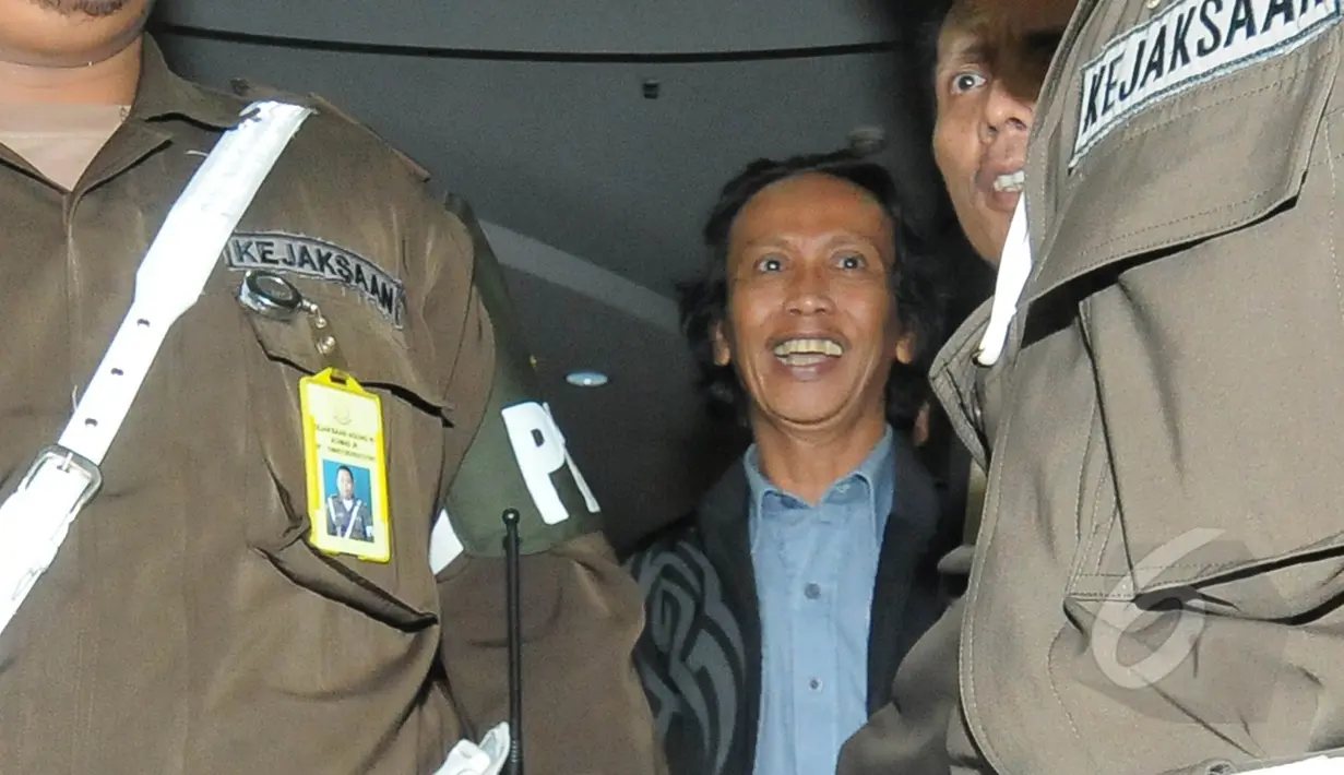 Mandra keluar dari gedung Kejaksaan Agung menuju mobil tahanan yang telah menjemputnya, Jakarta, Jumat (6/3/2015). Mandra ditahan karena diduga terlibat kasus penggelembungan dana di TVRI tahun 2012. (Liputan6.com/Herman Zakharia)