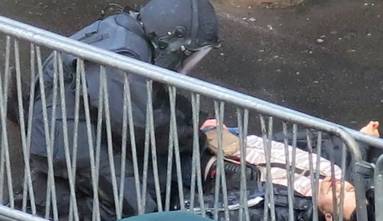 Polisi memeriksa jasad seorang pria yang ditembak mati di sebuah kantor polisi di Paris, Prancis, Kamis (7/1/2016). Pria itu ditembak mati karena memaksa masuk ke kantor polisi dengan mengenakan rompi peledak. (ANNA POLONYI/NEW YORK TIMES/AFP)