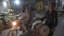 Pria Pakistan Lal Hussain (66) memukul drum saat membangunkan warga untuk sahur di Rawalpindi (30/5). Hussain adalah salah satu dari beberapa drumer yang tersisa yang masih melakukan tradisi berabad-abad membangunkan sahur.  (AFP Photo/Aamir Qureshi)