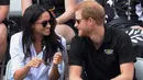 Pangeran Harry dan kekasihnya Meghan Markle berbincang saat menonton pertandingan tenis kursi roda selama Invictus Games 2017 di Toronto, Kanada, Senin (25/9). Selama pertandingan, keduanya tampak tertawa sambil sesekali berbisik satu sama lain (AP Photo)