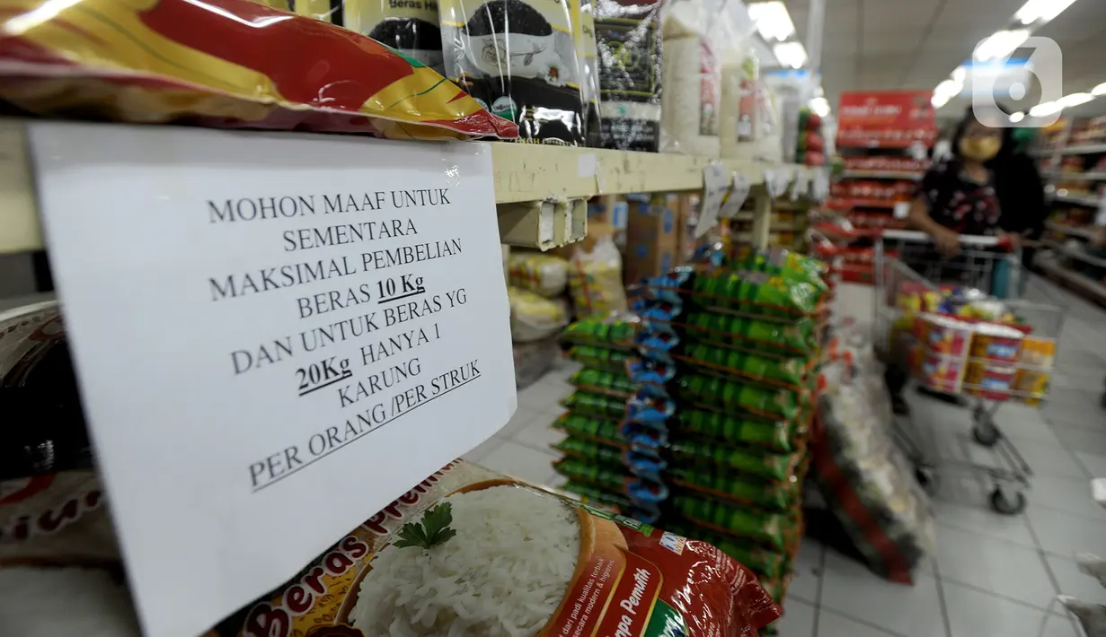 Pembeli berbelanja dekat kertas pemberitahuan pembatasan pembelian beras di supermarket Kawasan Cirendeu, Tangsel, Rabu (18/3/2020). Satgas Pangan meminta pedagang membatasi penjualan bahan pokok yakni beras, gula, minyak goreng dan mi instan untuk menjaga stabilitas harga. (merdeka.com/Arie Basuki)