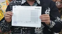 Komisioner KPU RI, Ilham Saputra menunjukkan sertifikat rekap hasil penghitungan suara di Provinsi Bali saat rapat Rekapitulasi Hasil Penghitungan Perolehan Suara Tingkat Nasional dan Penetapan Hasil Pemilu Tahun 2019, Jakarta, Jumat (10/5/2019). (Liputan6.com/Helmi Fithriansyah)