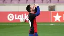 Striker Barcelona, Lionel Messi, menggunakan jersey Newell's Old Boys melakukan selebrasi saat melawan Osasuna pada laga Liga Spanyol di Stadion Camp Nou, Minggu (29/11/2020). Gol tersebut dipersembahkan untuk mendiang Diego Maradona. (AFP/J. Bassa)