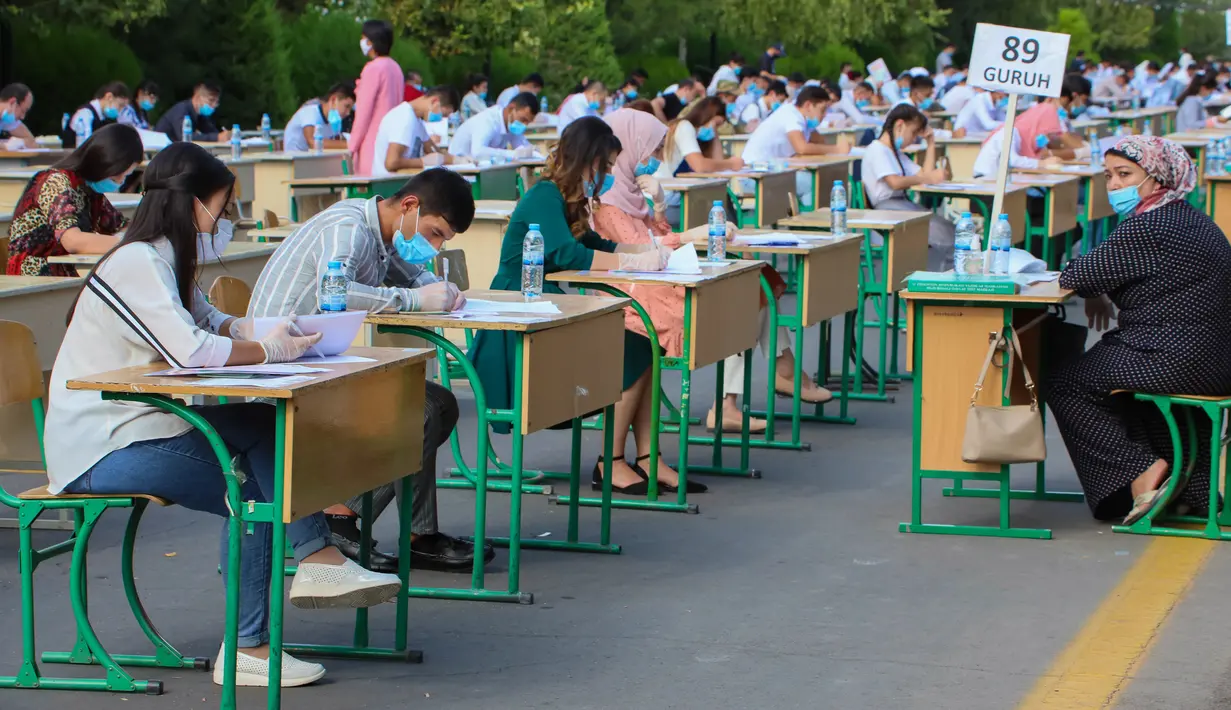 Para siswa Uzbekistan mengikuti ujian masuk luar ruangan, di tengah pandemi COVID-19 yang sedang melanda, di Tashkent pada Rabu (2/9/2020). (Photo by Yuri KORSUNTSEV / AFP)