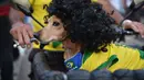  Seorang suporter Brasil menghiasi anjing kesayangannya dengan jersey Brasil dan wig kribo, Rio de Janeiro, Brasil, Kamis (12/6/2014) (AFP PHOTO/YASHUYOSHI CHIBA)