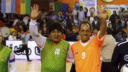 Evo Morales (kiri) dan Daniel Scioli, gubernur provinsi Buenos Aires dan calon presiden Argentina dari Victory menyapa penonton sebelum memainkan pertandingan sepak bola di Benavidez, Buenos Aires, Argentina (17/9/2015). (REUTERS/Marcos Brindicci)
