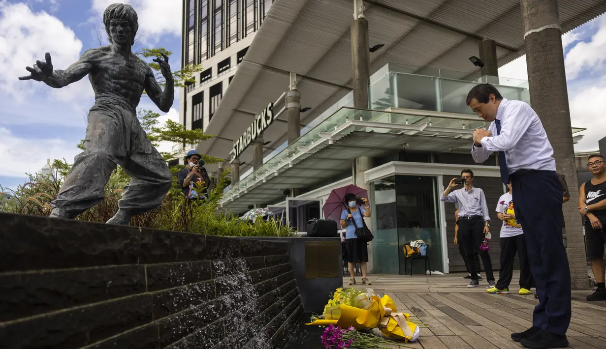 <p>Para penggemar berkumpul di depan patung seniman bela diri Bruce Lee untuk memperingati 50 tahun kematiannya di Hong Kong, Kamis, 20 Juli 2023. (AP Photo/Louise Delmotte)</p>