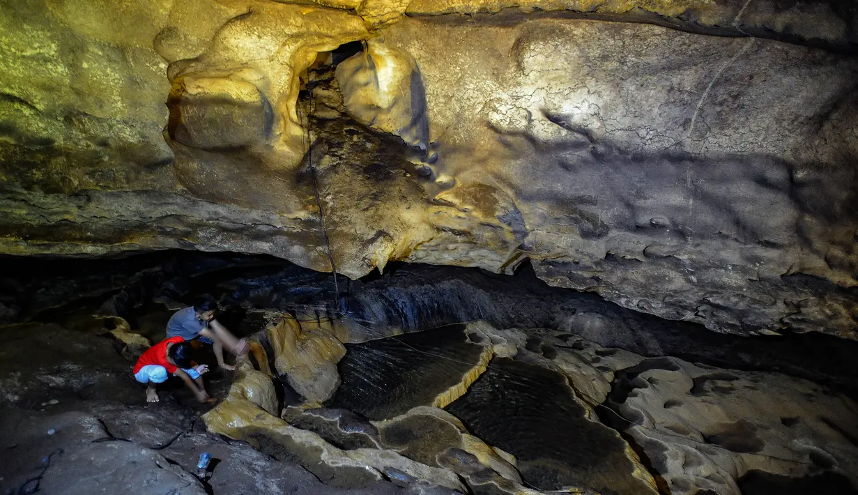 Dari total jalur tersebut, sekitar 850 meter telah dibuka untuk wisatawan, sementara sisanya masih berupa lorong alami yang hanya dapat ditembus dengan penyelaman karena terpotong sungai bawah tanah sedalam 10 meter. Tampak dalam foto, aktivitas pengunjung di dalam Goa Lowo di Watuagung, Trenggalek, Jawa Timur. (merdeka.com/Arie Basuki)