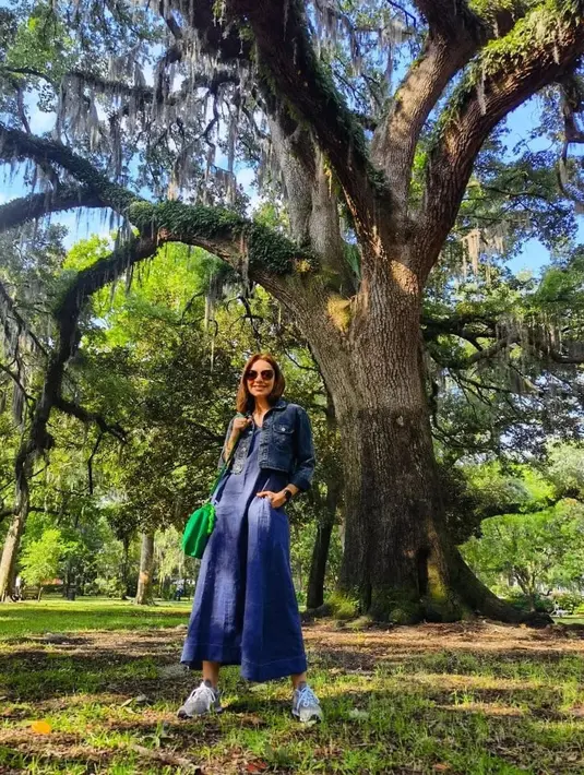 Najwa Shihab sendiri memilih tampilan denim on denim. Jumpsuit denim ditumpuknya dengan denim cropped jacket. Najwa memadukannya dengan sneakers putih, tas berwarna hijau, dan sunglasses. Foto: Instagram.
