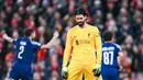 Kiper Liverpool, Alisson Becker, tampak kecewa setelah ditaklukkan PSG lewat adu penalti 0-1 (1-4) dalam laga leg kedua 16 besar Liga Champions 2024/2025 yang digelar di Anfield, Rabu (12/3/2025) dini hari WIB. (AFP/Oli Scarff)