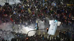 Usai menyaksikan laga final Piala Dunia 2014 antara Jerman vs Argentina, ribuan suporter Timnas Argentina bentrok dengan polisi anti huru hara di Buenos Aires, (14/7/2014). (REUTERS/Ivan Alvarado)