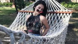 Meski memiliki segudah kesibukka, Ranty Maria selalu menyempatkan waktu untuk berlibur. Kali ini pesinetron cantik ini tampak duduk bersantai di atas hammock. Gaya simpel dengan kacamata itu membuatnya semakin kece. (Liputan6.com/IG/@rantymaria)