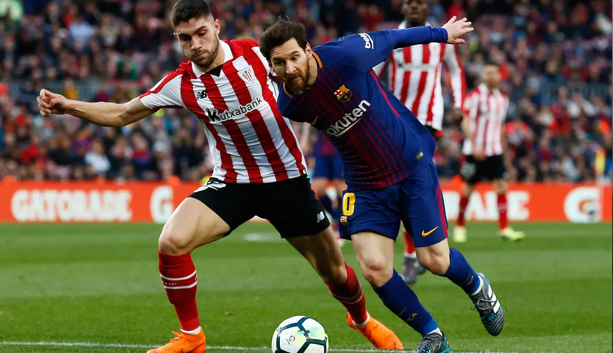 Pemain Athletic Bilbao Unai Nunez berusaha menghadang laju Lionel Messi saat pertandingan La Liga Spanyol di stadion Camp Nou di Barcelona (18/3). (AP Photo/Manu Fernandez)