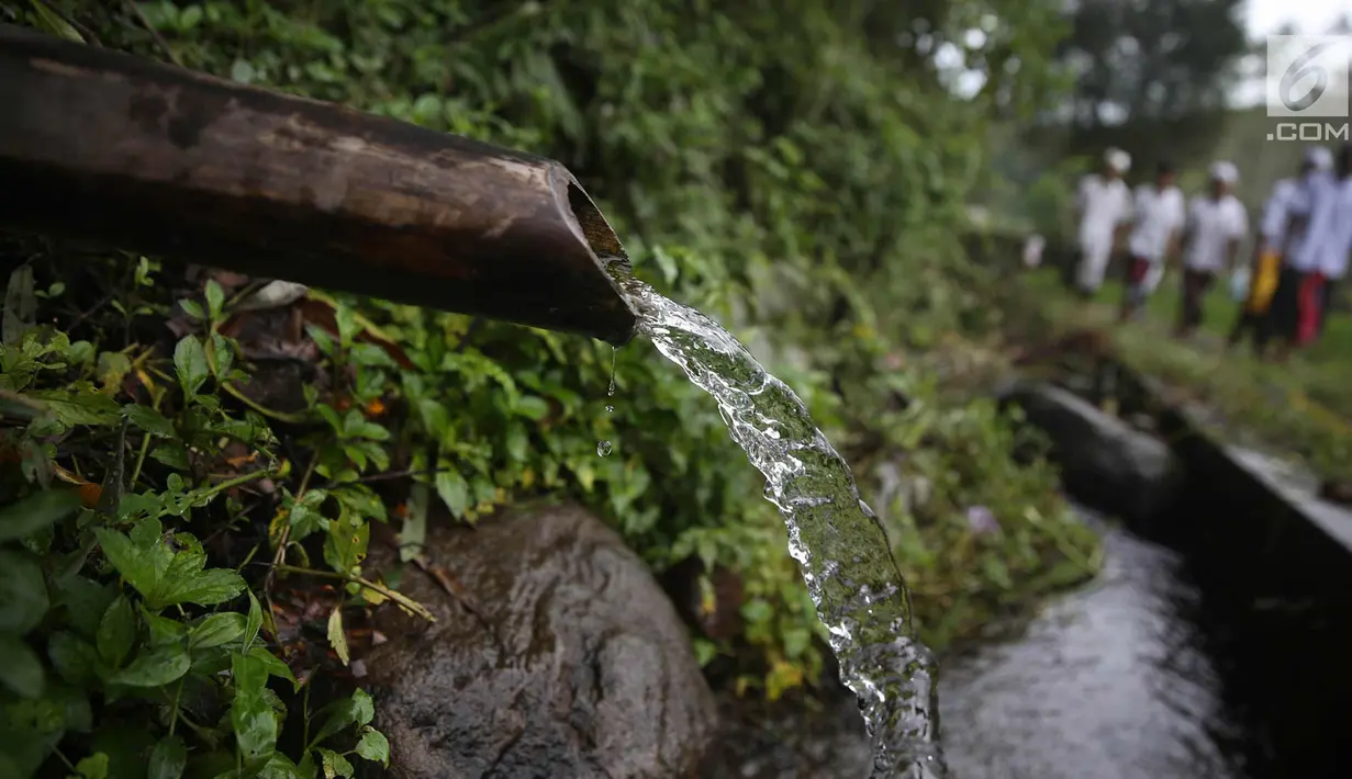 Warga berjalan untuk beribadah di sekitar Sungai Yeh Sah, Desa Batusesa, Kec Rendang, Karangasem, Bali, Jumat (1/12). Warga berharap diberi keselamatan dan berkah dari erupsi Gunung Agung yang terjadi. (Liputan6.com/Immanuel Antonius)